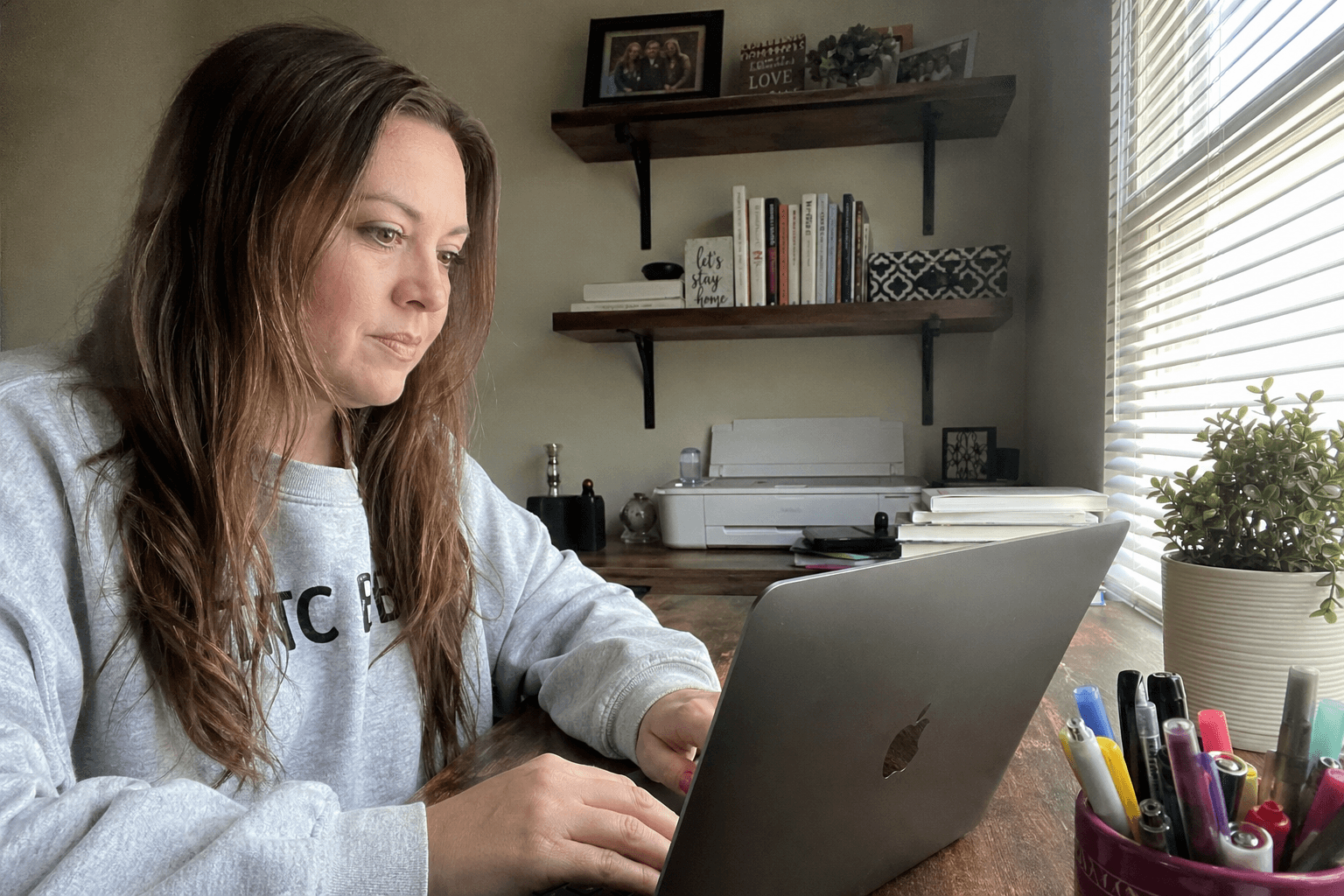 Kūrėja prie nešiojamo kompiuterio su RESÈT Home Care valikliais ant stalo