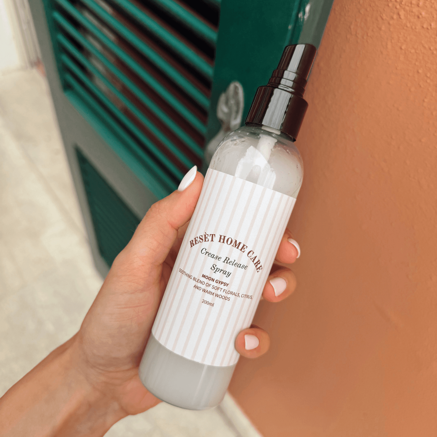 Purškalo buteliukas šalia kabančio kostiumo švarko prieš verslo kelionę