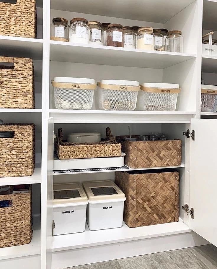 Tvarkingai sudėti rūbai medinėse spintos lentynose su lygia kompozicija