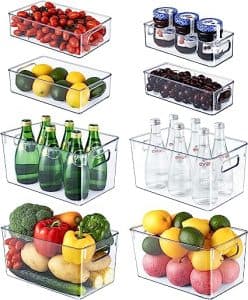 Tvarkingai sudėti maisto produktai skaidriose dėžutėse baltame šaldytuve